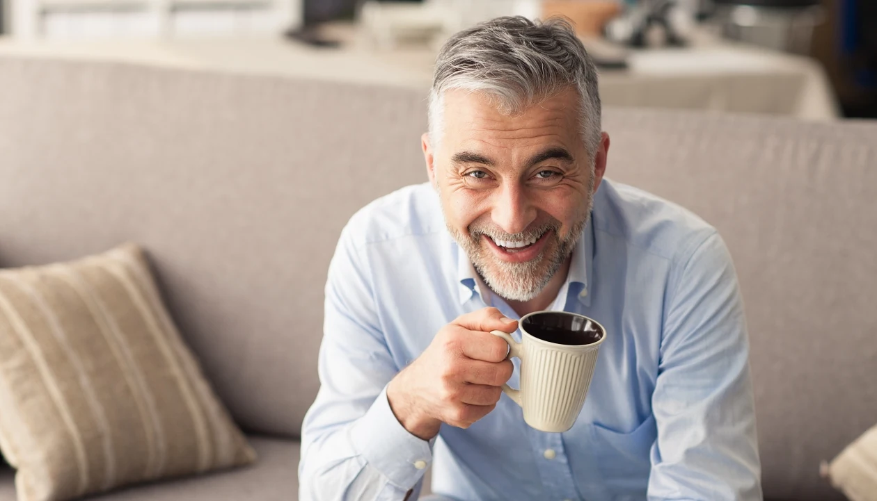 Happy man holding a cup of coffee