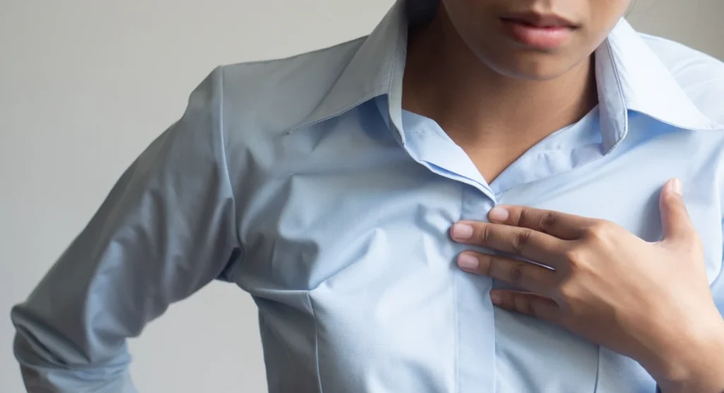 Man holding his chest while experiencing GERD