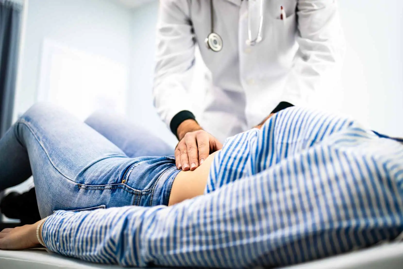 Doctor examining a patient's stomach as part of a gastroparesis surgery evaluation